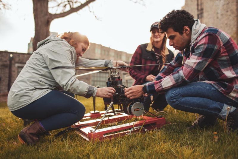 A group of Virginia Tech biological system engineering graduate students work together on a drone