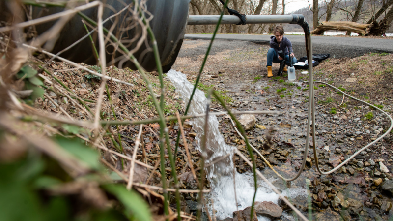 Image of Leigh-Anne Krometis examining a water source in rural Appalachia.